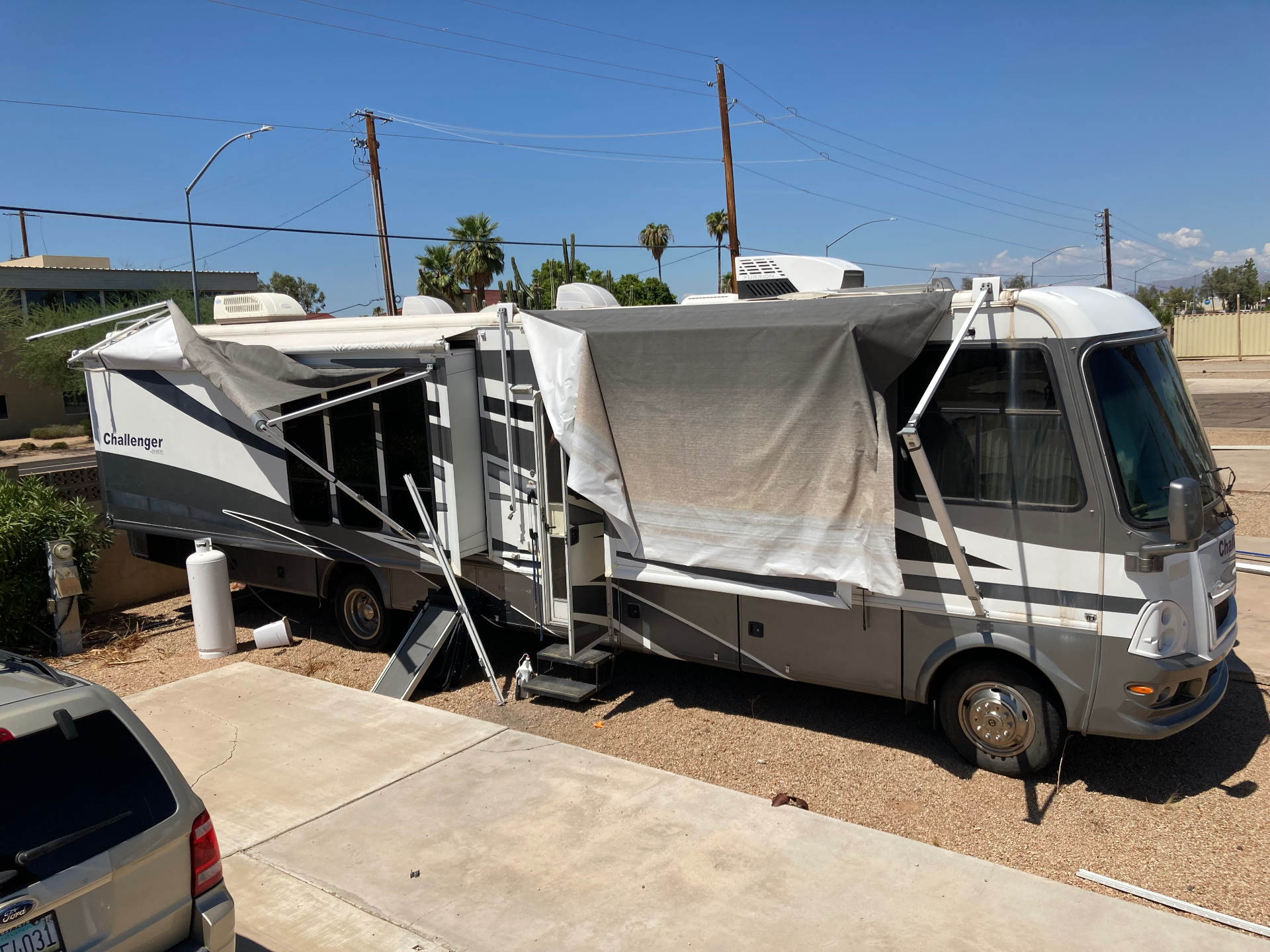 Storm-damaged RV awning with bent arms awaiting an insurance claim repair