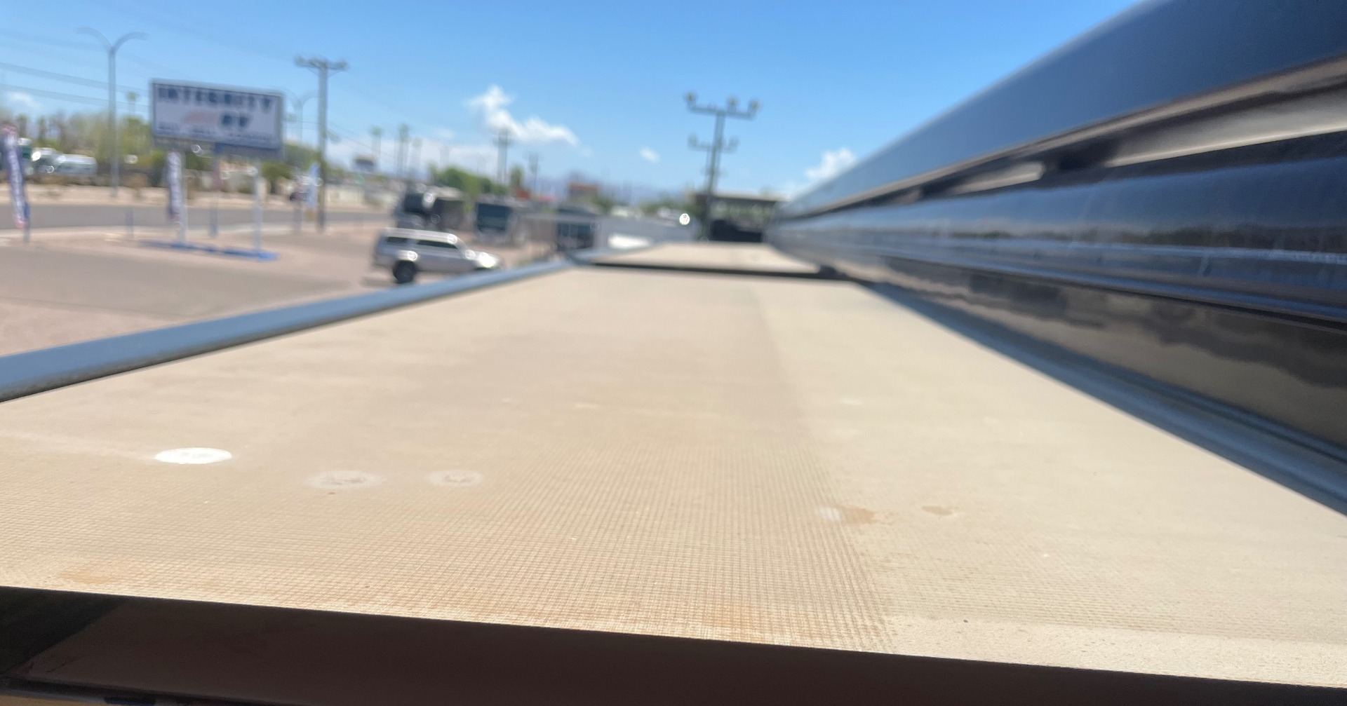 Worn, stained tan awning fabric on an RV before replacement